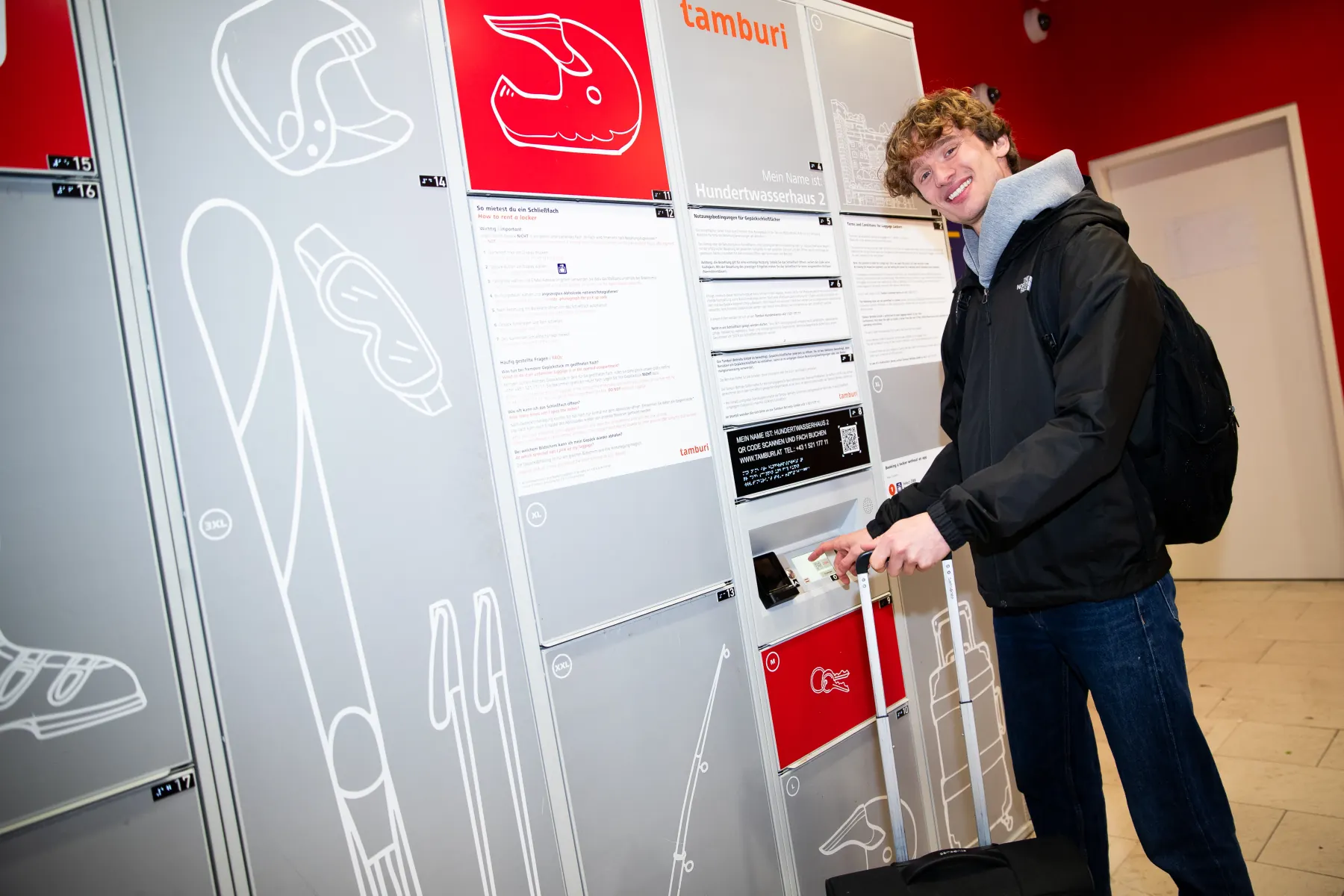 Person verstaut Gepäck im Schließfach